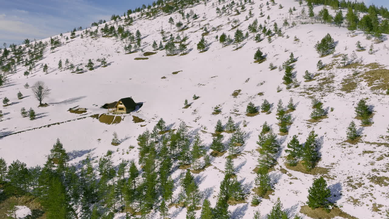 Remote Wooden Cabin on a Snowy Mountain Slope