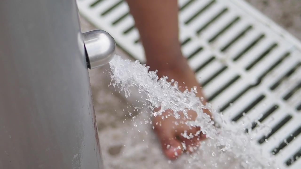 Person Washing Feet Under Outdoor Shower
