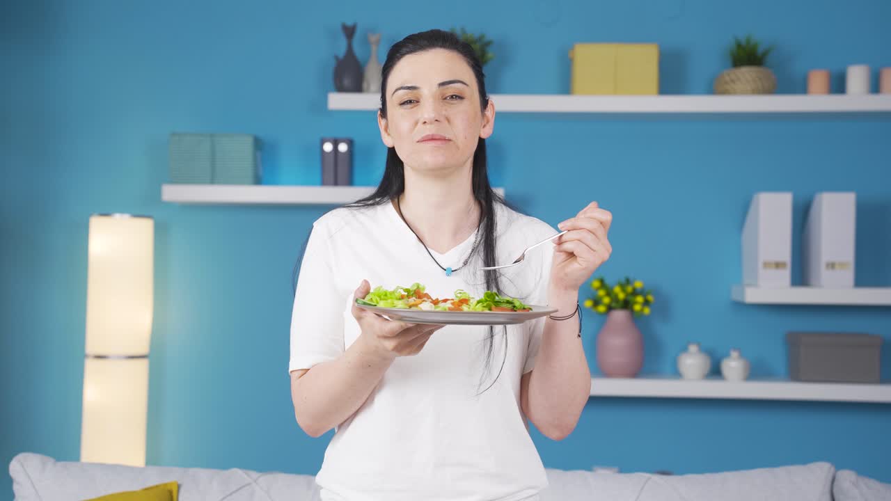 The person holding a plate of salad is laughing.