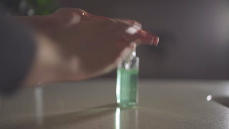 Woman's-hand-enters-frame-and-applies-hand-sanitizer