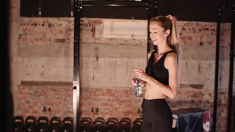 Zeitlupe-Einer-Jungen-Sportlichen-Frau-Mit-Wasserflasche-Im-Fitnessclub