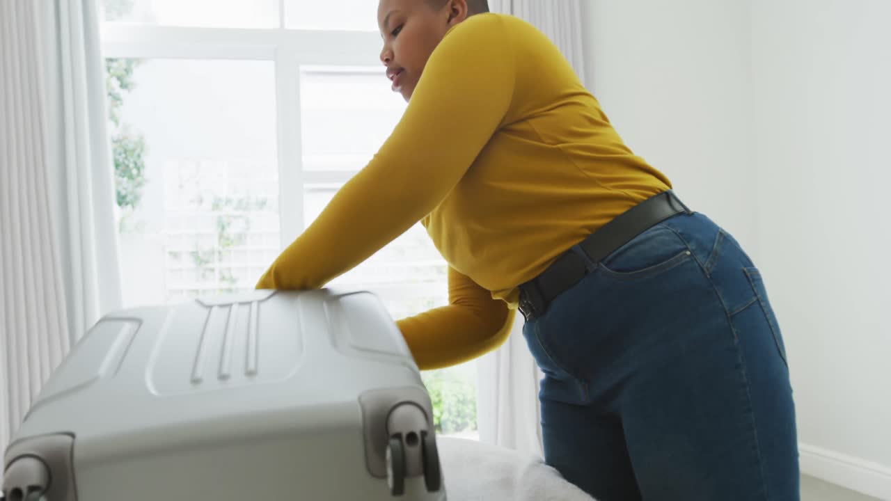 행복한 아프리카계 미국인 플러스 사이즈 여성 침실에서 수하물을 포장