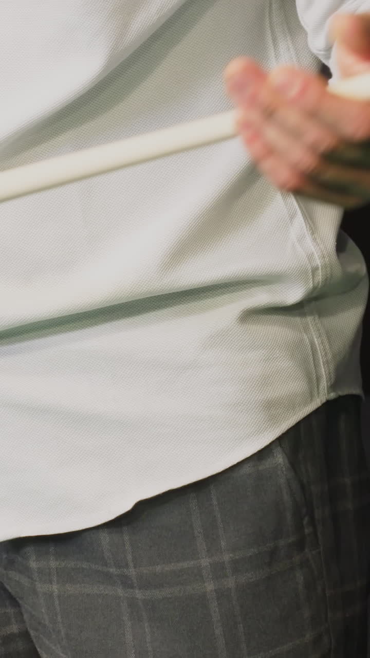 색 셔츠와 회색 바지를 입은 사람, 얼굴이 보이지 않고, 녹색 빌리어드 테이블 에서 큐 스틱을 집어 들고, 손, 빌리어드의 공, 장비에 집중합니다.