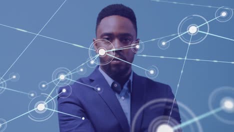 Animation-of-network-of-connections-over-african-american-businessman-on-blue-background