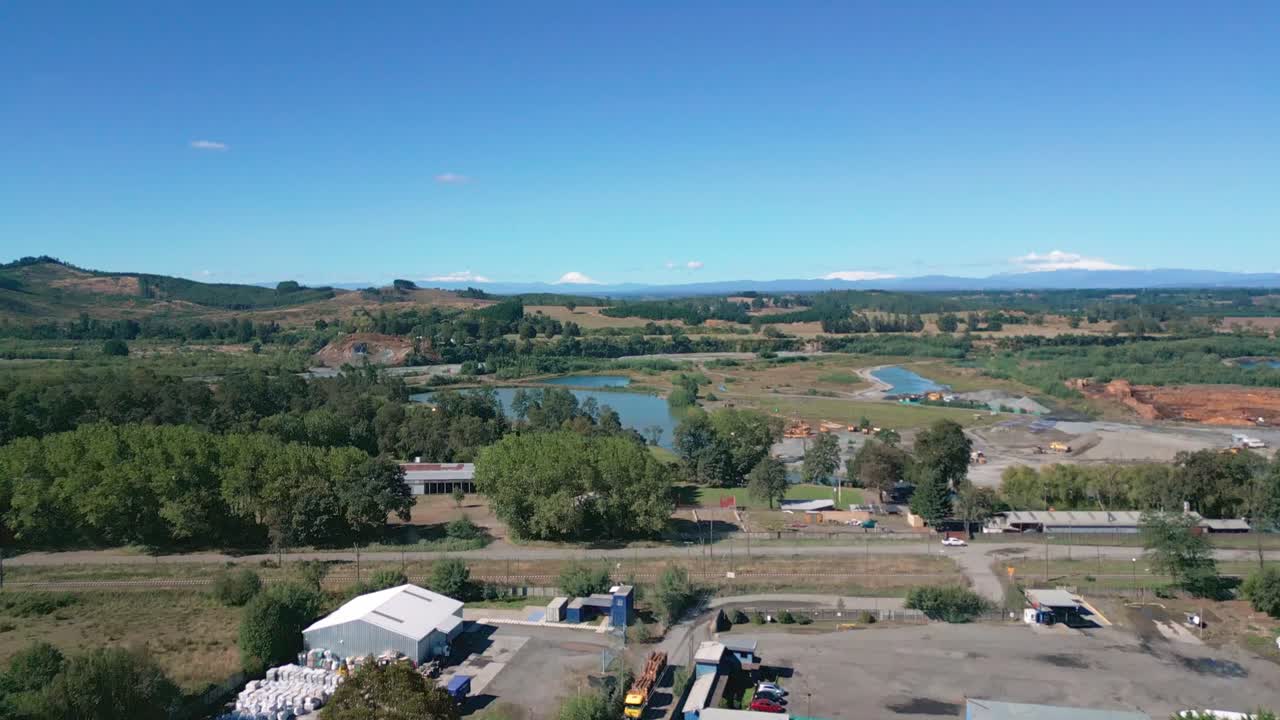 Vista ascendente de un pueblo rural con estanques y campos a lo lejos.