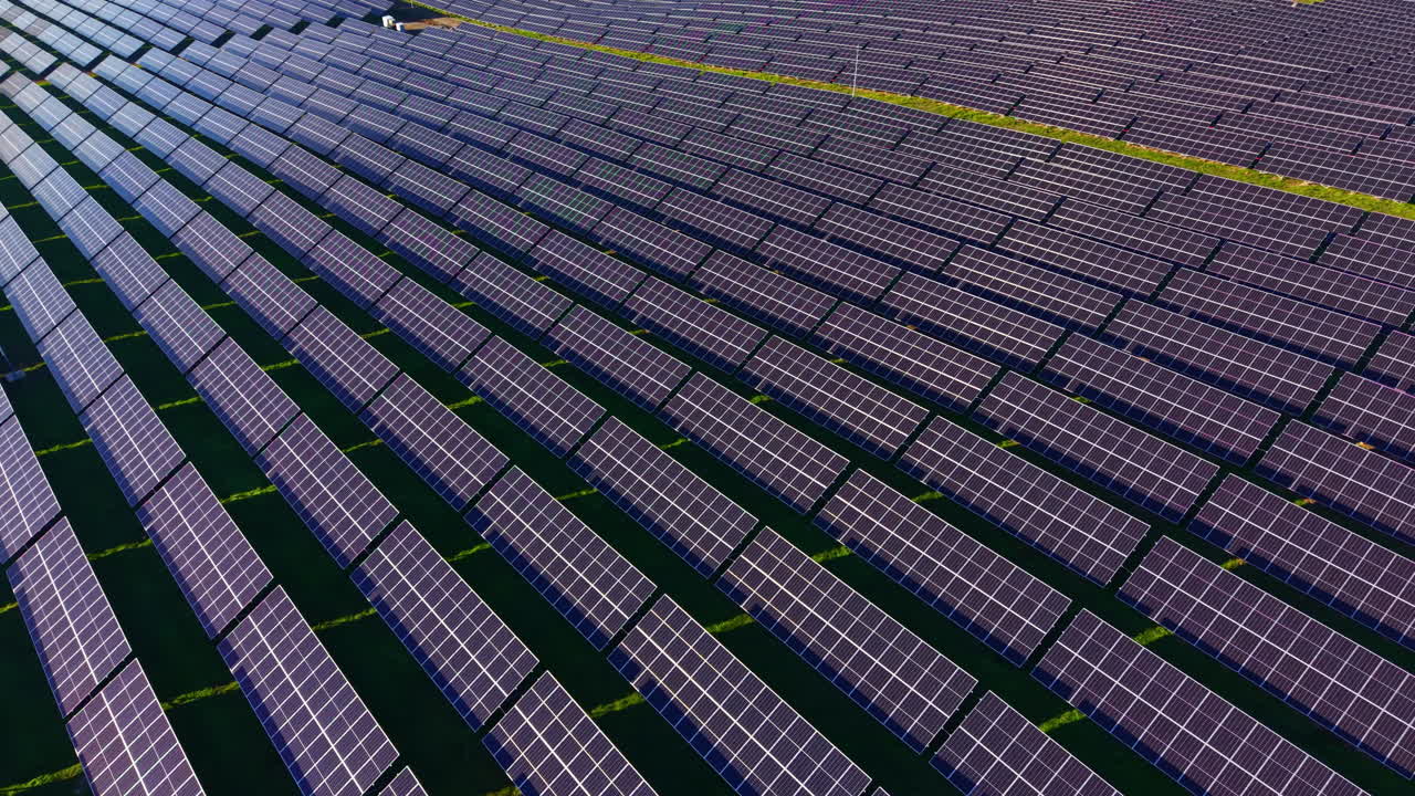 Vasto array di pannelli solari cattura la luce del sole in un paesaggio incontaminato sotto un cielo azzurro e limpido a mezzogiorno