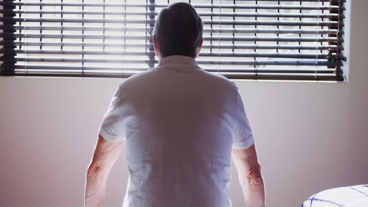 vista trasera de un hombre mayor sentado en la cama de examen 4k