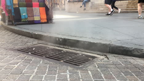 steam rising from new york city street grate and people walking by