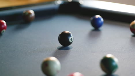 billiard balls are meticulously arranged in triangular formation on a pool table lit by warm sunlight, signaling the start of a friendly game among friends.