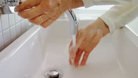 Senior-woman-washing-her-hands-in-sink-4k