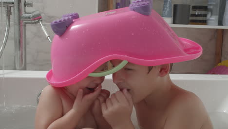 playful kids trying to be invisible under toy bathtub