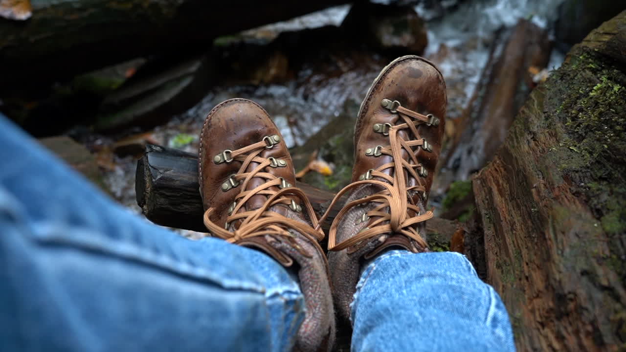 Hiker Relaxing on a Log by the Creek.