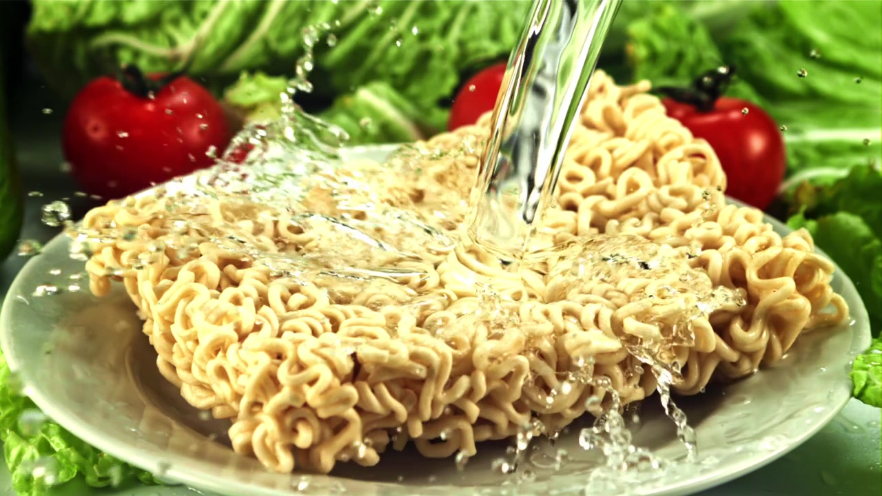 Pouring Water Over Dry Instant Noodles with Fresh Vegetables
