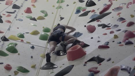 Person-climbing-colorful-indoor-rock-wall,-sport-and-fitness-challenge