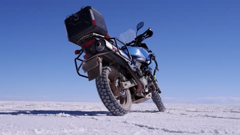 Low-angle-view-of-motorcycle-parked-on-Uyuni-Salt-Flat-lake,-Bolivia