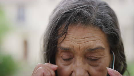 Nahaufnahme-Porträt-Einer-Hübschen-älteren-Indischen-Frau,-Die-Eine-Brille-Aufsetzt,-Glücklich-Lächelt-Und-In-Die-Kamera-Blickt-Und-Einen-Entspannten-Lebensstil-Im-Ruhestand-Genießt.-Eine-ältere-Frau-Mit-Faltiger-Haut