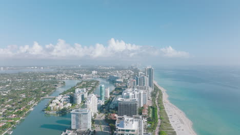 Aerial-panoramic-footage-of-tall-modern-buildings-in-urban-borough-on-sea-coast.-Forwards-fly-above-town.-Miami,-USA