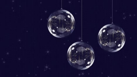 Animation-of-snow-falling-over-glass-christmas-baubles-on-black-background