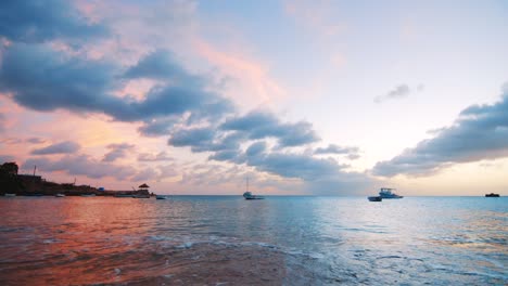 Paisaje-De-La-Playa-De-Múltiples-Barcos-De-Pesca-Tendidos-En-El-Puerto-Durante-La-Puesta-De-Sol-En-Boka-Sami,-Curacao