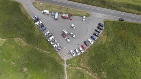 aerial view of a rural car park and road surrounded by green fields
