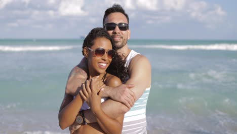 abrazando a una pareja diversa en la costa
