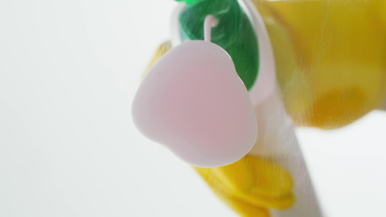 Hand in Yellow Glove Spraying Cleaning Liquid on Surface