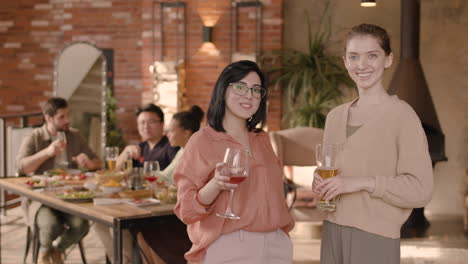 two young women talking at a dinner party