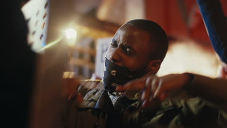 lower view of african american man yelling with arms up in a protest with multiethnic group of people in the street