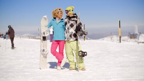 Happy-young-couple-posing-with-their-snowboards