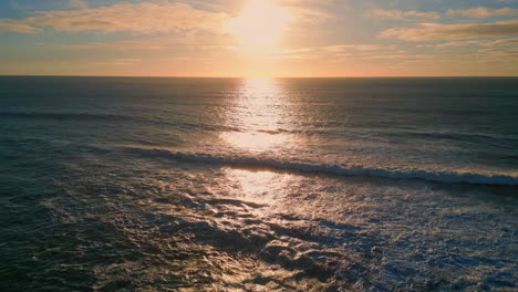 golden sunset sky rippling ocean surface drone view. sea reflecting sunlight