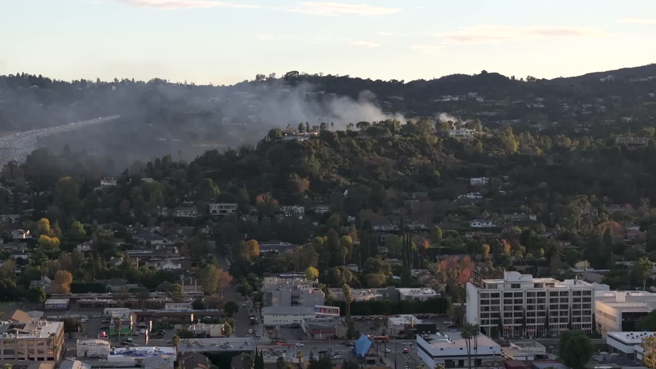 incendio en las colinas por encima de las casas de varios millones de dólares en encino, california - aérea