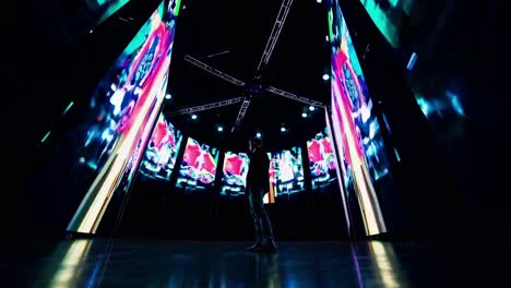 Wide-angle shot of a futuristic video setup with vibrant digital screens surrounding a person