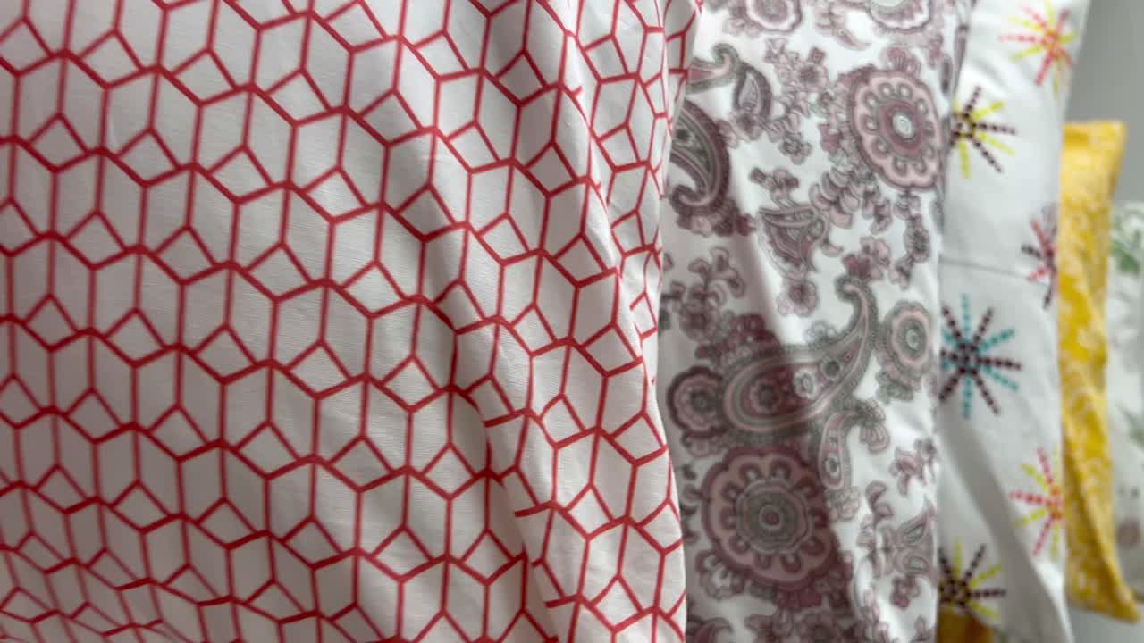 A moving shot of soft colorful pillows placed in a queue
