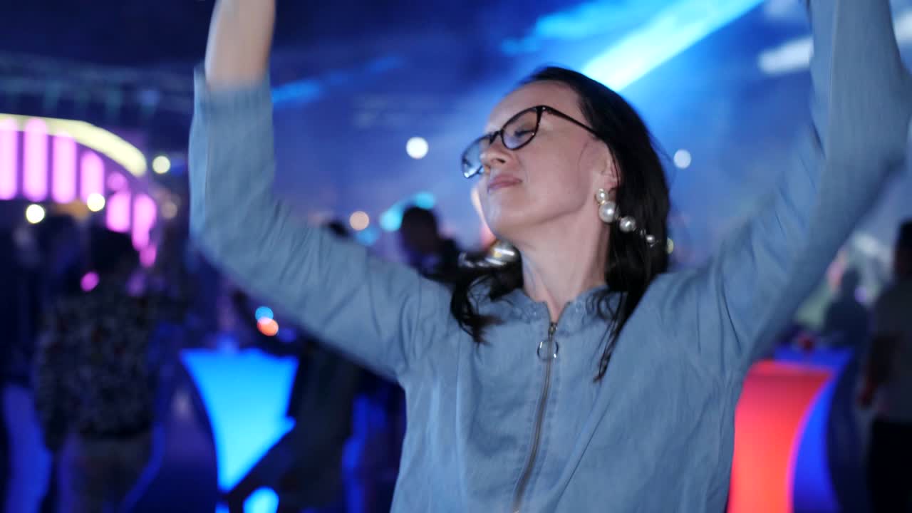 mujer bailando en la luz osney y reflectores para fiesta nocturna o festival de baile al aire libre.