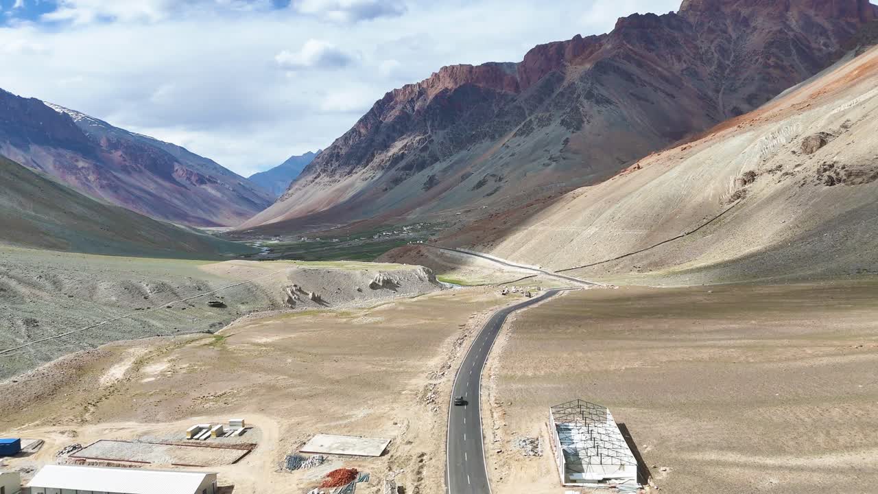 Aerial drone shot capturing the stunning, rugged landscape of Ladakh with its vast mountain ranges.