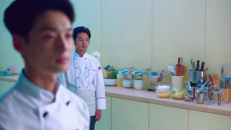 two chefs in a modern kitchen setting
