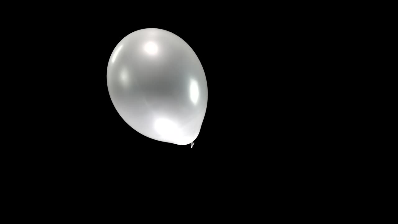 Watch a single silver balloon as it falls gracefully, turning in the air with smooth, elegant motion. The reflective surface catches the light, creating a captivating and dynamic visual effect
