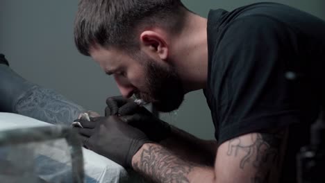 maestro de pintura de tatuaje tatuaje con máquina en el brazo en el salón