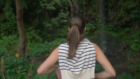 model girl looking at a waterfall in the jungle in madeira portugall , deep in the green forest