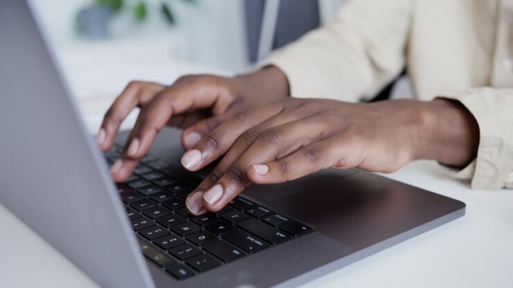 Person, die auf dem Laptop eingibt