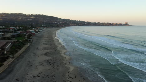 Vista-Aérea-De-Turistas-Disfrutando-De-La-Playa-En-La-Costa-De-La-Jolla-En-San-Diego-En-Una-Puesta-De-Sol---Dron-Descendente