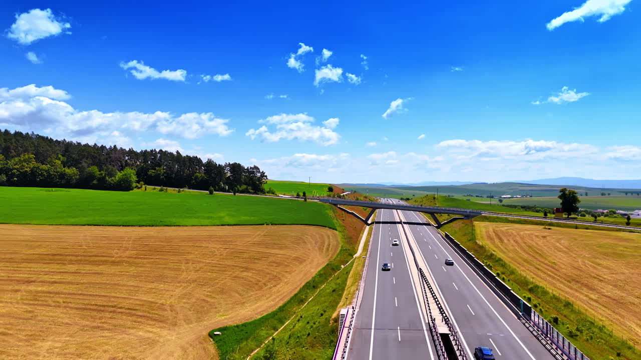 Flying over the multi-lane highway in the picturesque nature landscape. Cars ride by the road in the rural area of Slovakia