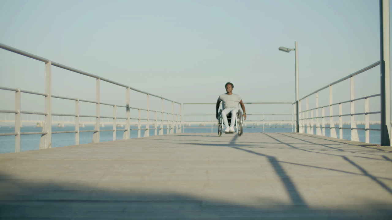 해안가에서 휠체어를 타고 흑인 남자의 전면보기 샷
