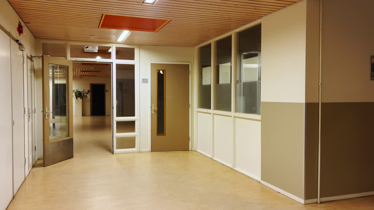 Empty office school building hallway with wooden ceiling and white walls in March 2026. Interior view of clean modern school or hospital corridor with doors leading to rooms and offices