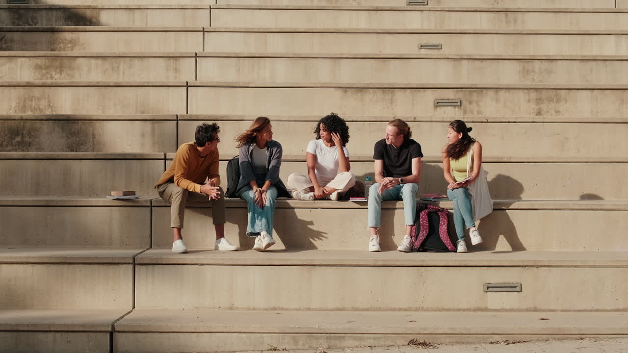Close up of cheerful young student tells stories to his friends