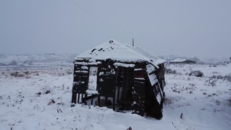 Drone-View-Of-Old-Abandoned-Rustic-Building-In-The-Snow