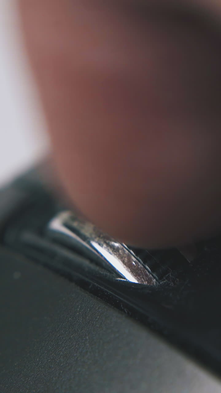 person turns wheel on contemporary black computer mouse in white background extreme close view