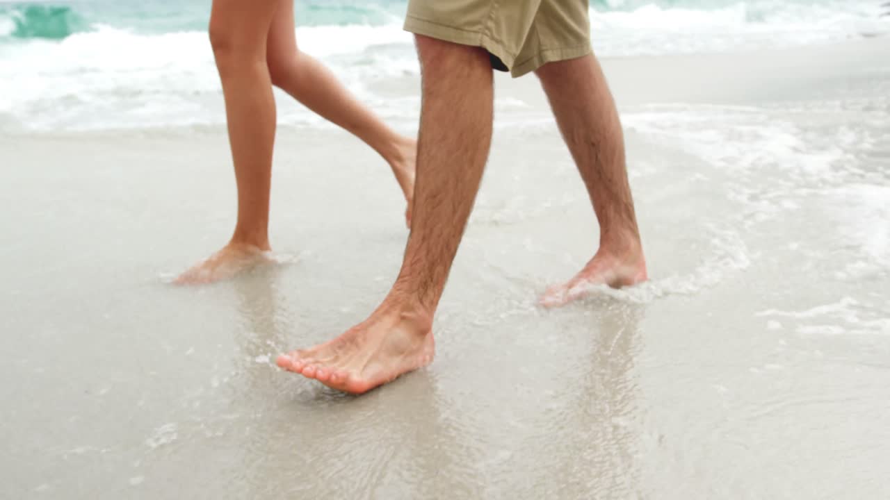 해변에서 맨발로  ⁇ 는 커플의 낮은 섹션 4k