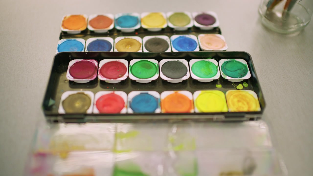 Close up view of a watercolor paint set with multiple colors neatly arranged
