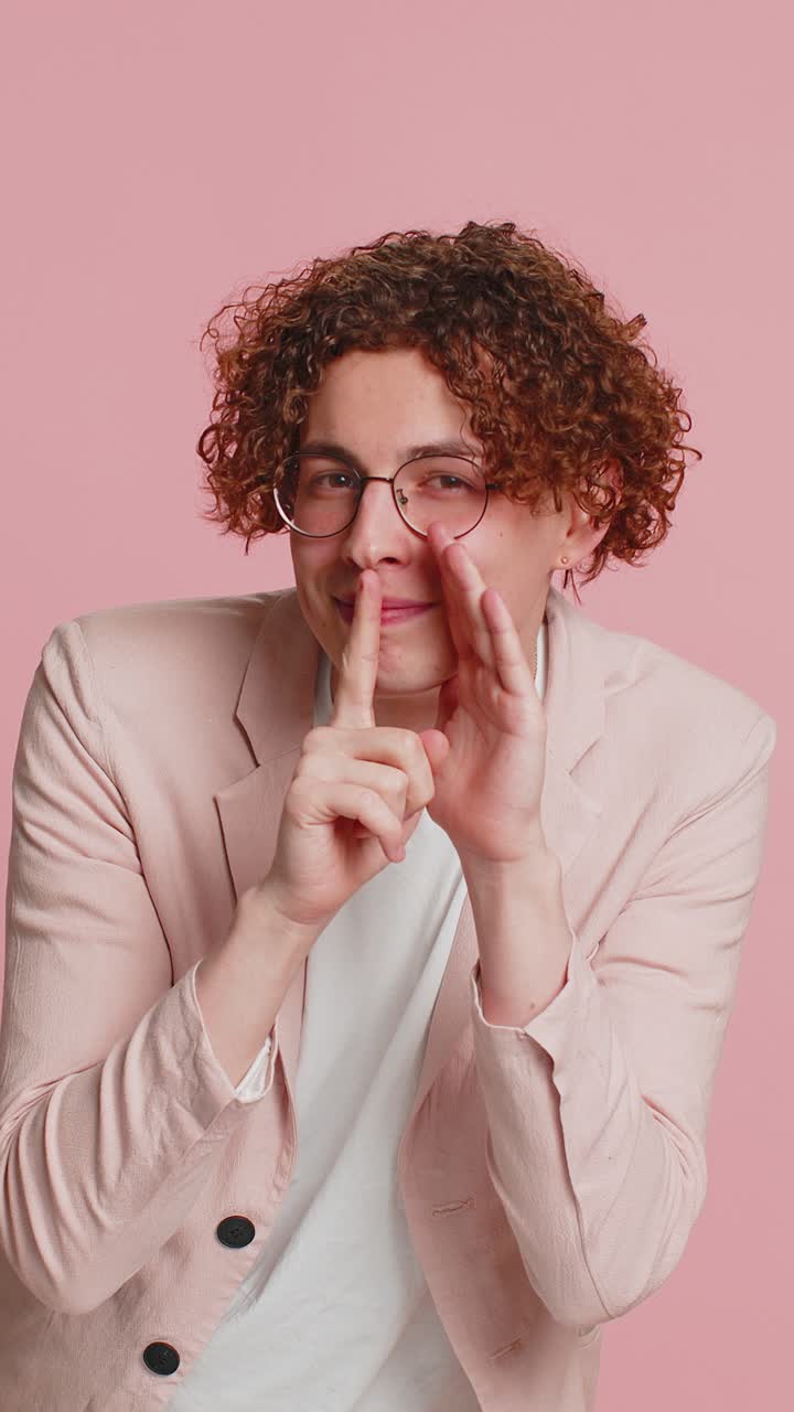 joven susurra noticias rumores tomándose de la mano cerca de la boca compartir chismes tranquilo mantener mis secretos